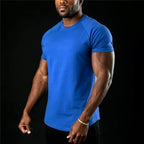 PrimeBuild Essential Training Tee in blue on a model, angled view of the slim fit and short raglan sleeves