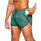Man in green split-hem running shorts with black trim and drawstring waist, sliding a phone into the side zippered pocket