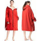 Front and back views of the red PrimeBuild Swim Parka on models, showing hood, front zip, cuff tabs and side splits