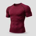 PrimeBuild Men's Compression Training Shirt in Wine Red, angled view with crew neck and dark contrast raglan seams