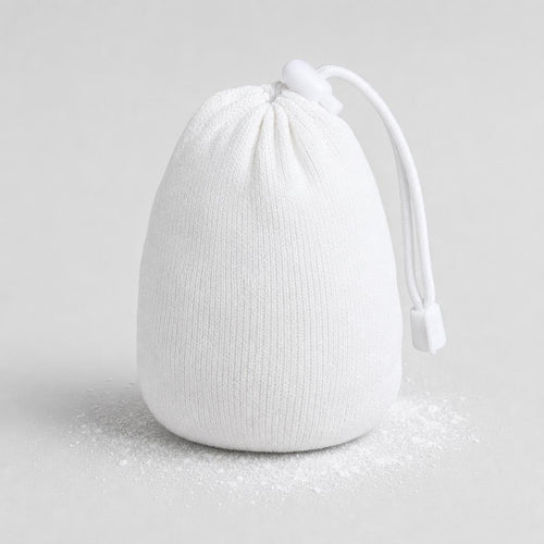 PrimeBuild Chalk Ball, a white cotton chalk sock with drawstring and toggle lock, on a light surface with loose chalk