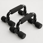PrimeBuild Push-Up Bars, pair of glossy black U-shaped bars with black foam grips and foam-capped feet on white