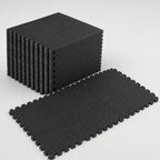 PrimeBuild Interlocking Foam Gym Mat in black, a stack of tiles beside six tiles joined into a flat puzzle floor
