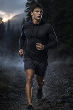 Man running on a misty trail wearing the PrimeBuild Men's Quick-Dry Hooded Training Shirt in black with dark shorts