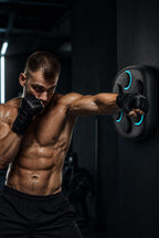 PrimeBuild Smart Music Boxing Trainer on a dark gym wall as a man in black fingerless gloves throws a punch