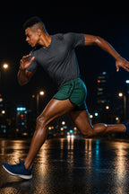 Man sprinting on a wet city street at night wearing green PrimeBuild Men's Performance Running Shorts
