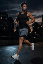 Man running on a city street at dusk wearing PrimeBuild Men's 2-in-1 Training Shorts in gray with a black liner