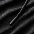 Close-up of the black textured knit fabric and drawstring cord tip on the PrimeBuild Hooded Training Shirt