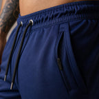 PrimeBuild Men's 7" Running Shorts close-up of the navy fabric, zippered side pocket, elastic waistband and black drawstring
