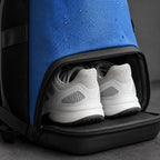 PrimeBuild Gym Backpack shoe compartment unzipped at the base holding white sneakers, water beading on the blue fabric
