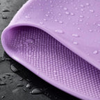Close-up of a lilac PrimeBuild Silicone Swim Cap showing the textured dotted anti-slip interior with water droplets