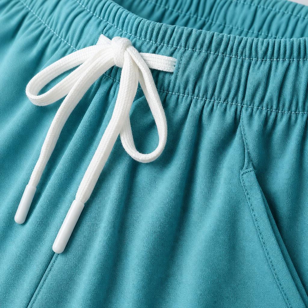 Close-up of PrimeBuild Lightweight Training Shorts in teal blue showing the elastic waistband, white drawcord and side pocket