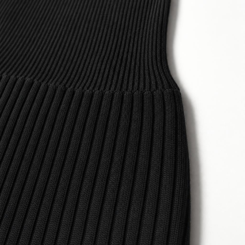 Close-up of the black ribbed stretch knit of the PrimeBuild Seamless Jumpsuit, where a wider-ribbed band meets the finer rib