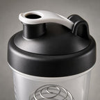 Close-up of the PrimeBuild shaker's black screw-on lid with white flip cap, drinking spout and carry loop