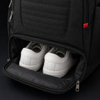 Open bottom shoe compartment of the PrimeBuild Water-Resistant Gym Backpack holding a pair of white sneakers