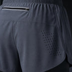 Close-up of PrimeBuild Men's 2-in-1 Training Shorts in gray: zippered back pocket, laser-cut vent holes and split hem