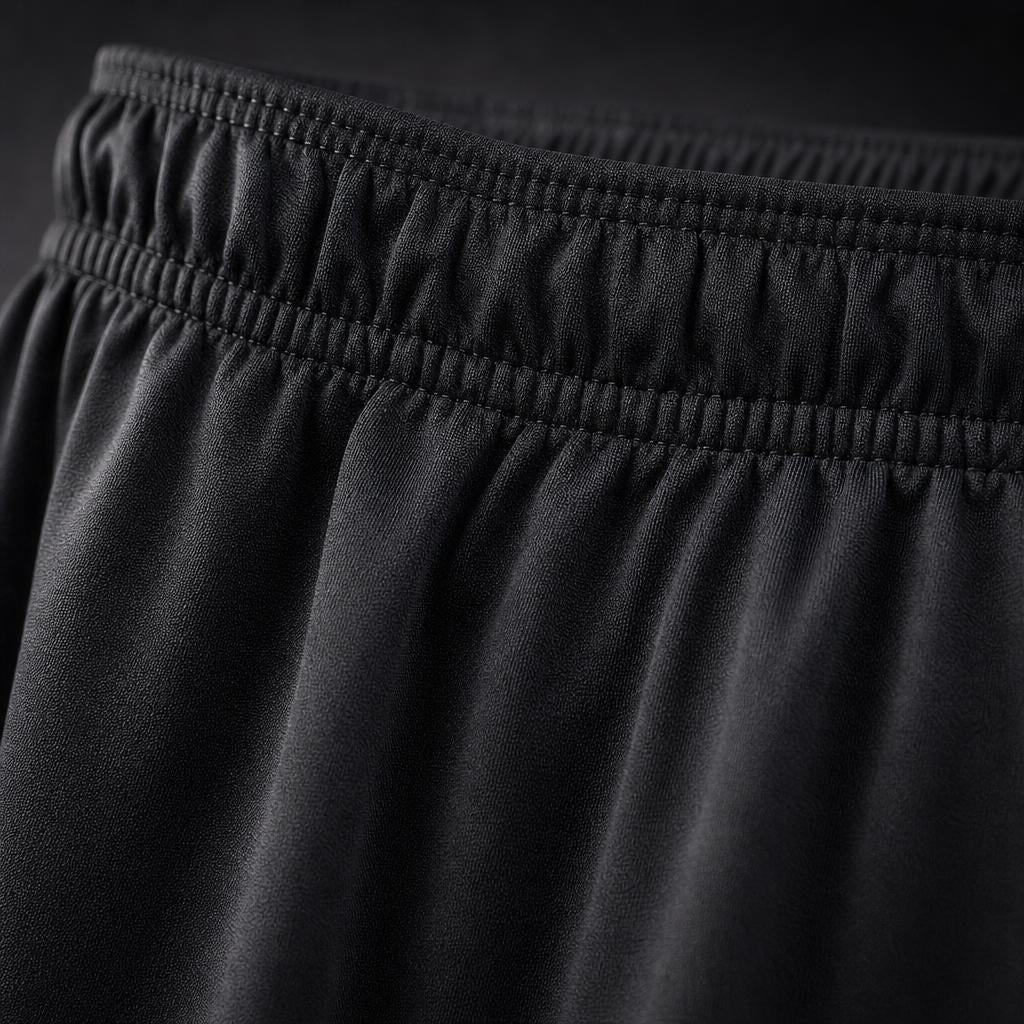 Close-up of the gathered elastic waistband and smooth black fabric of PrimeBuild Men's Performance Training Shorts