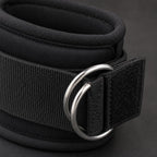 Close-up of the PrimeBuild ankle strap showing the double metal D-rings, stitching and hook-and-loop closure