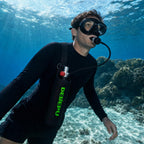 Snorkeler breathing from the DEDEPU mini scuba tank in its sling bag over a shallow reef