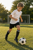 Kids' Soccer Shin Guards Set – child dribbling a ball in the striped knee-high socks and pocket sleeves